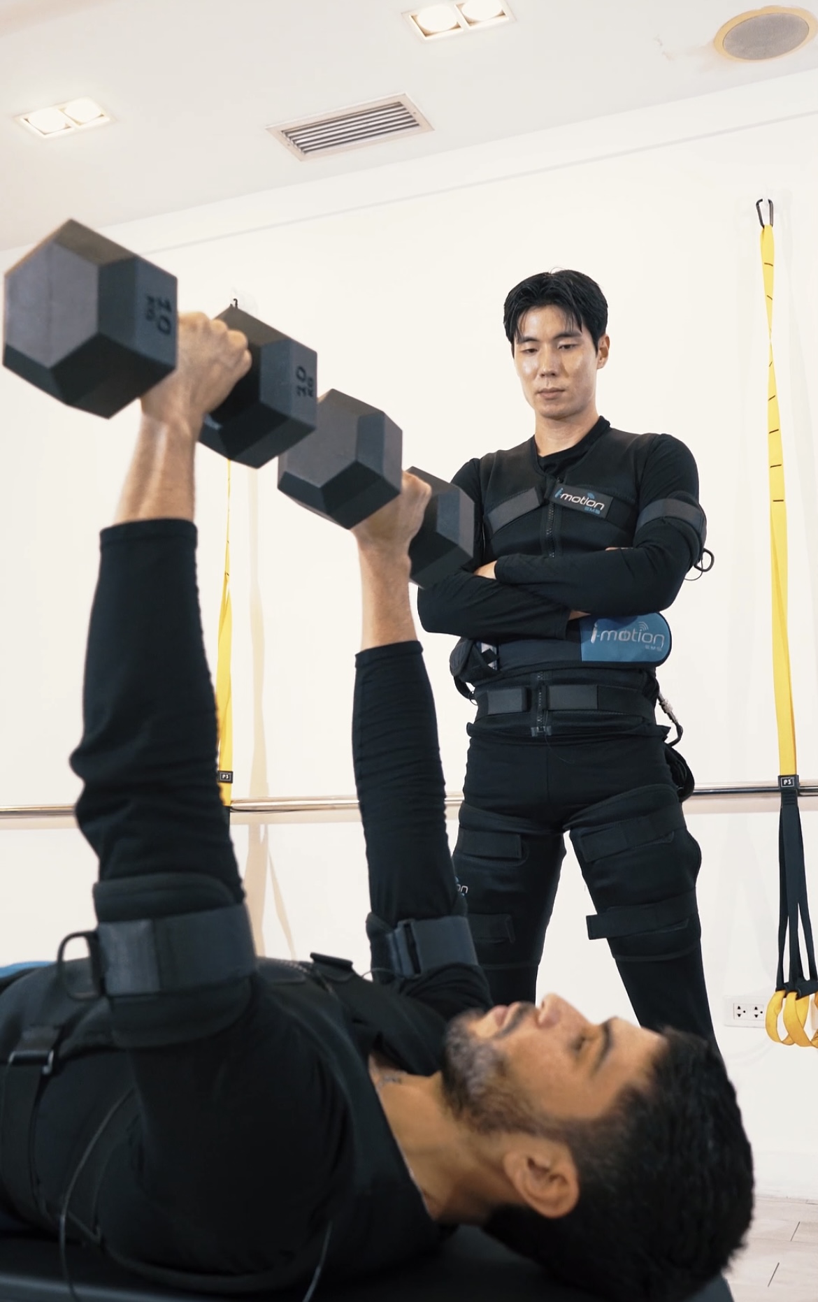 Person training with EMS suit in a modern fitness studio